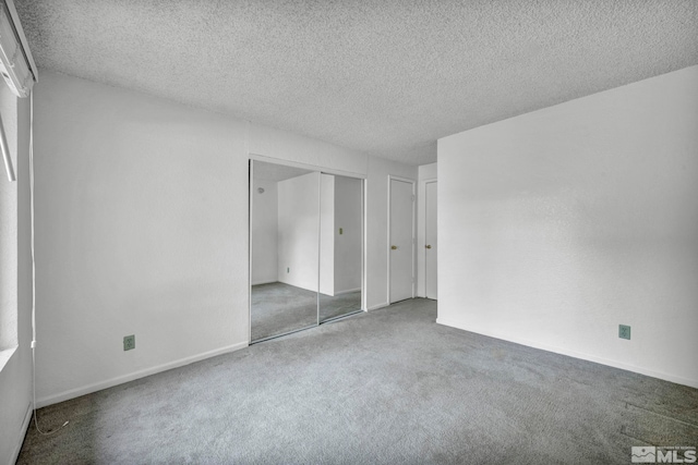 unfurnished bedroom with a textured ceiling and carpet flooring