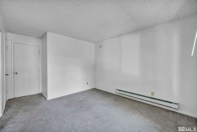 carpeted empty room with baseboard heating and a textured ceiling