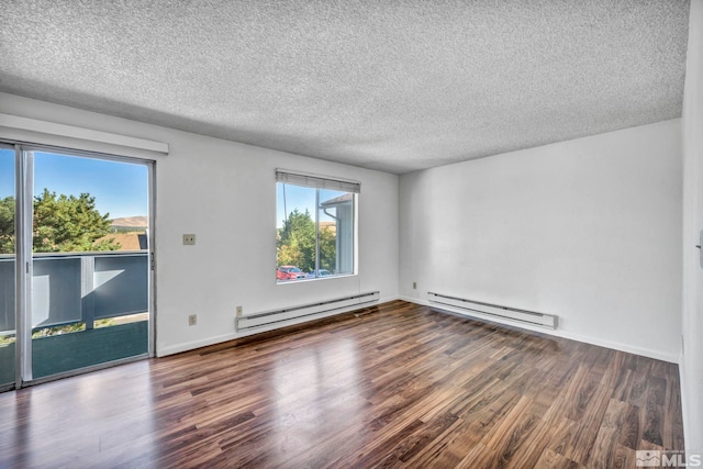 spare room with a baseboard heating unit, dark wood finished floors, a textured ceiling, and baseboards