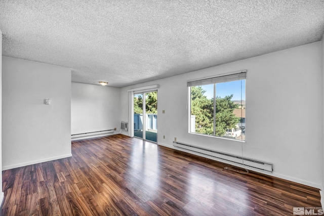 spare room with dark wood-type flooring, baseboards, a textured ceiling, and baseboard heating