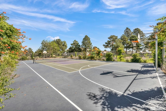 view of sport court with a tennis court, community basketball court, and fence