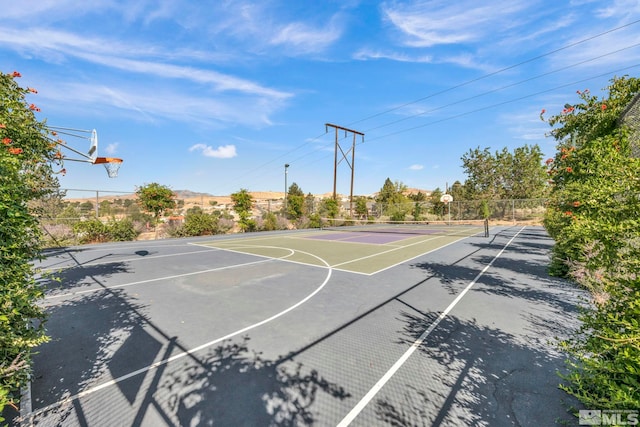 view of basketball court with community basketball court, a tennis court, and fence