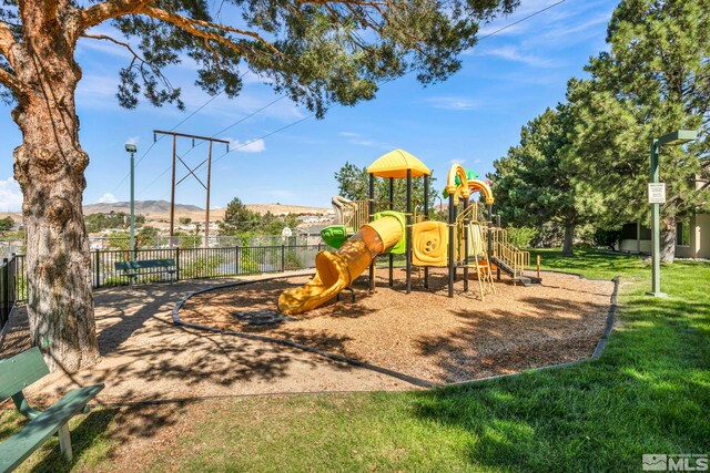 community playground featuring a yard, fence, and a mountain view