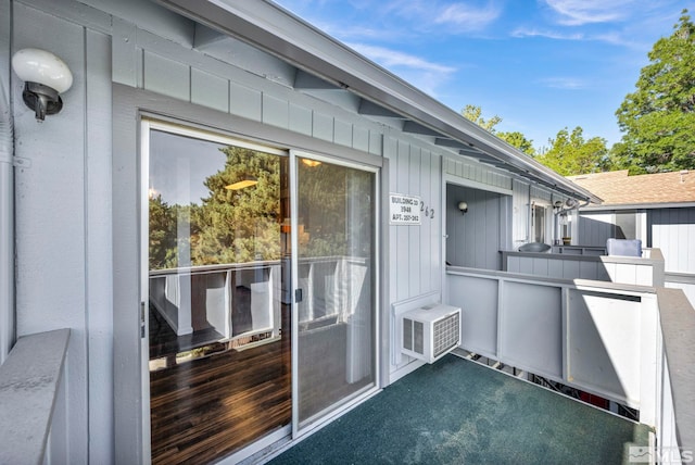 property entrance featuring board and batten siding and cooling unit