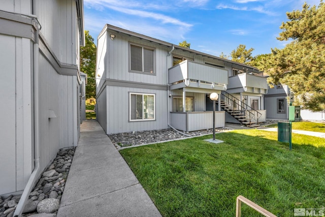 view of front of property featuring stairway and a front lawn