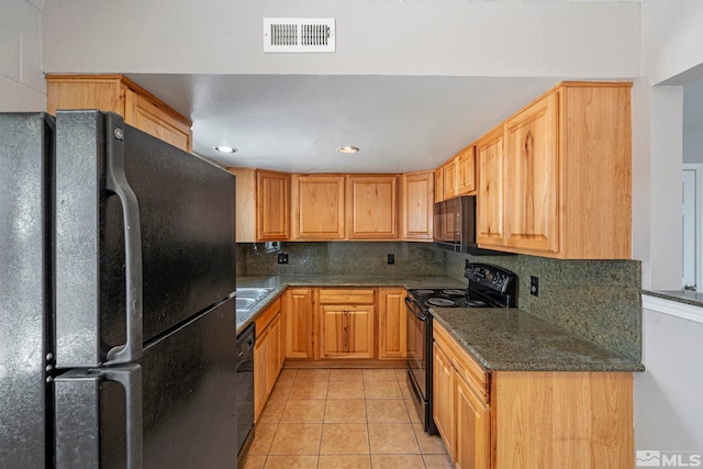 kitchen featuring light tile patterned floors, visible vents, backsplash, dark stone counters, and black appliances