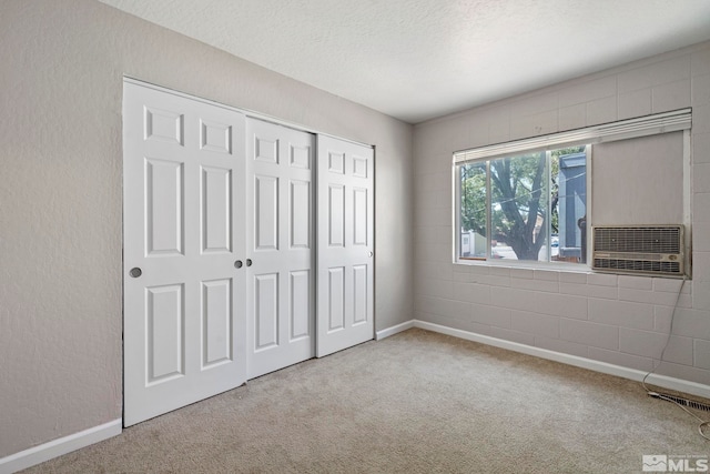 unfurnished bedroom featuring a textured ceiling, light carpet, visible vents, baseboards, and a closet