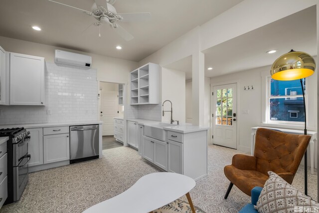 kitchen with decorative backsplash, a wall unit AC, white cabinets, sink, and stainless steel appliances