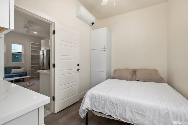 bedroom featuring ceiling fan, an AC wall unit, hardwood / wood-style floors, and stainless steel refrigerator