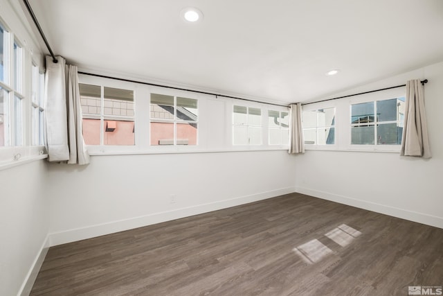 empty room featuring dark wood-style flooring, recessed lighting, and baseboards