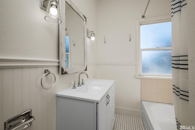 bathroom featuring tile patterned flooring, washtub / shower combination, and vanity