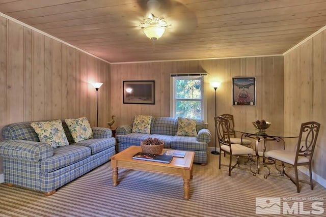 carpeted living room with wood walls, wooden ceiling, and ornamental molding