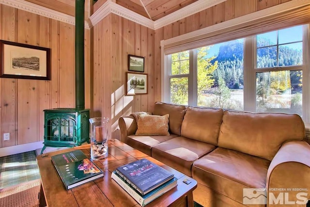 living room with wood walls, carpet flooring, crown molding, and a wood stove