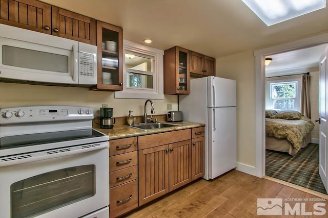 kitchen with sink, light hardwood / wood-style floors, and white appliances