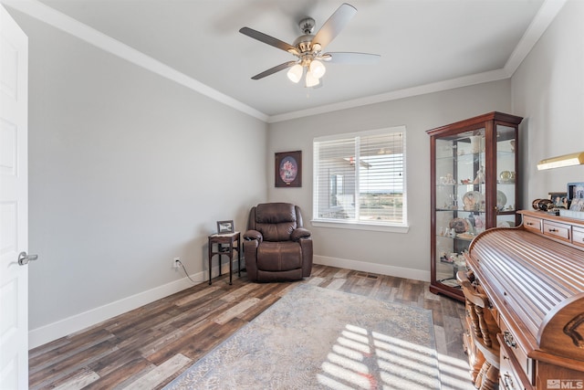 sitting room featuring a ceiling fan, crown molding, baseboards, and wood finished floors