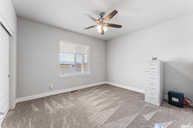 unfurnished bedroom featuring a ceiling fan, carpet, visible vents, and baseboards