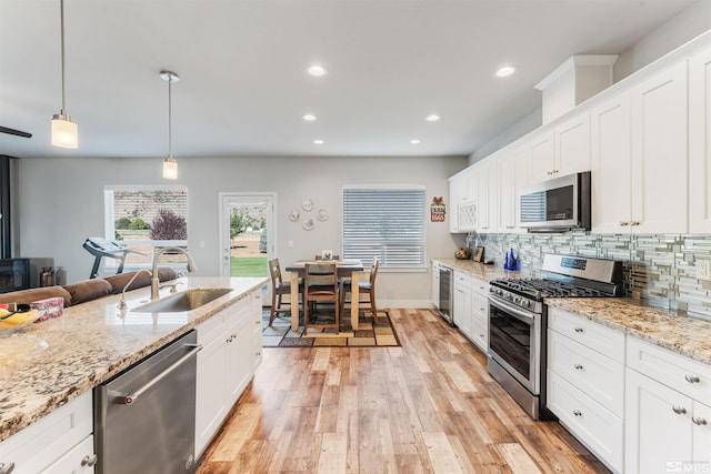 kitchen with decorative backsplash, wine cooler, appliances with stainless steel finishes, light wood-type flooring, and a sink