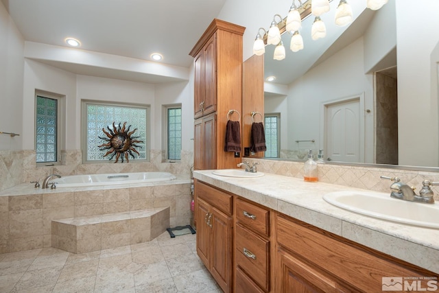 bathroom featuring double vanity, a bath, a sink, and lofted ceiling