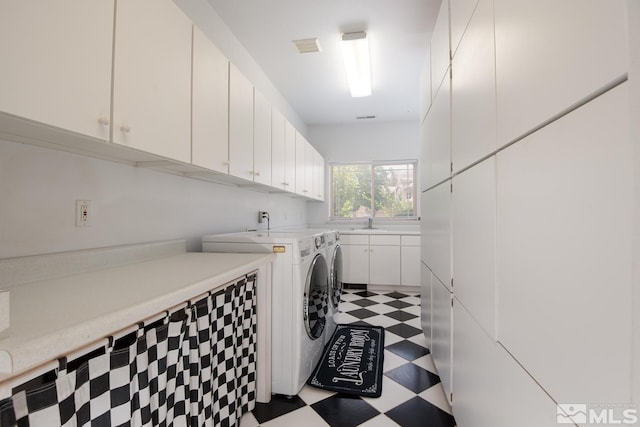 clothes washing area featuring a sink, visible vents, washer and dryer, cabinet space, and light floors