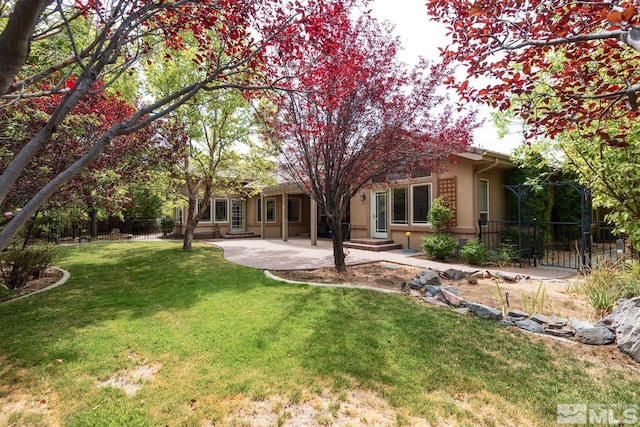 back of house featuring a patio, a lawn, fence, and stucco siding