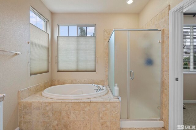 bathroom with a healthy amount of sunlight and separate shower and tub