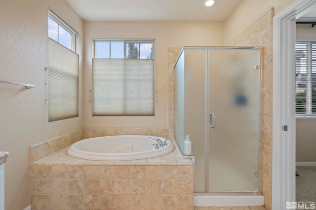 bathroom featuring a stall shower, plenty of natural light, and a bath