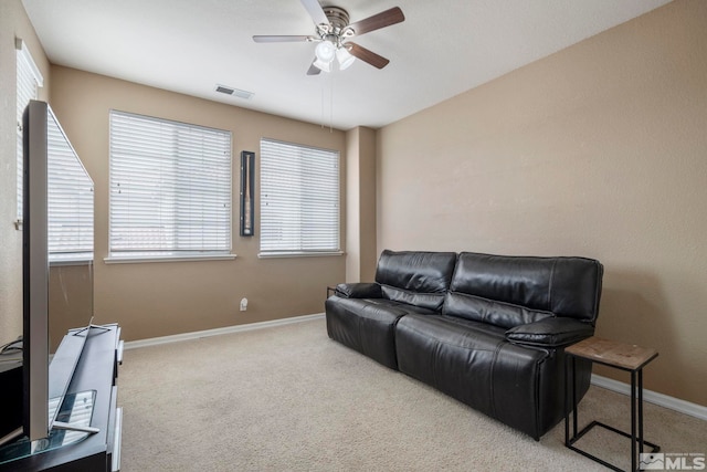 living room featuring light carpet, ceiling fan, visible vents, and baseboards