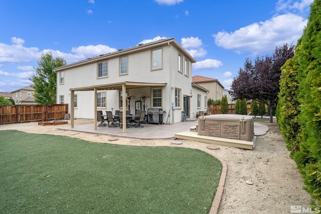 back of house with a patio, a lawn, and a hot tub