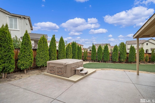 view of patio featuring a fenced backyard, a residential view, and a hot tub