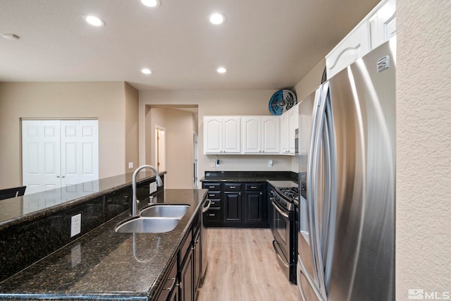 kitchen with sink, stainless steel fridge with ice dispenser, light wood-type flooring, and white cabinetry