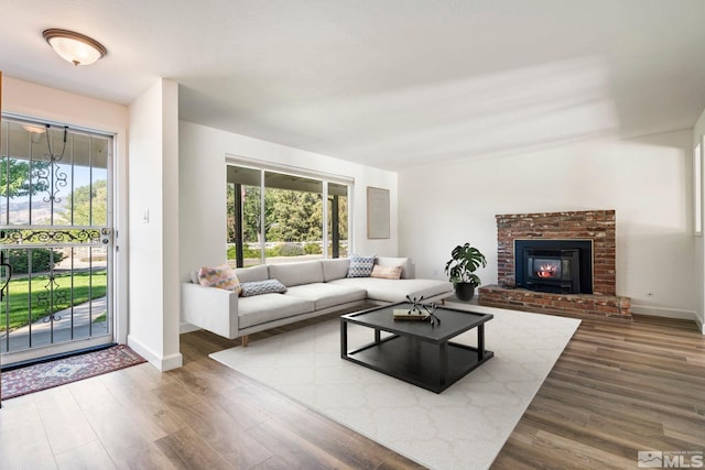 living room with hardwood / wood-style floors and a brick fireplace