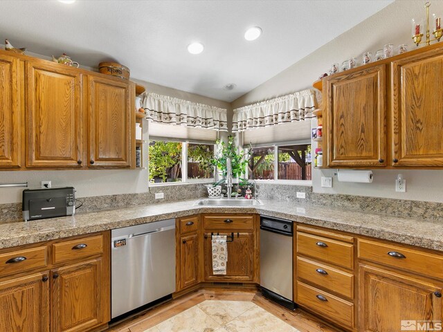 kitchen with a wealth of natural light, vaulted ceiling, and stainless steel dishwasher