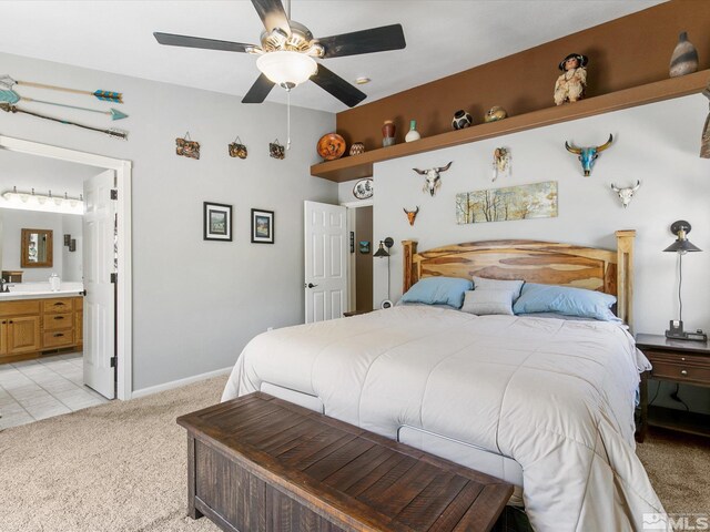 bedroom featuring light colored carpet, ensuite bathroom, sink, and ceiling fan