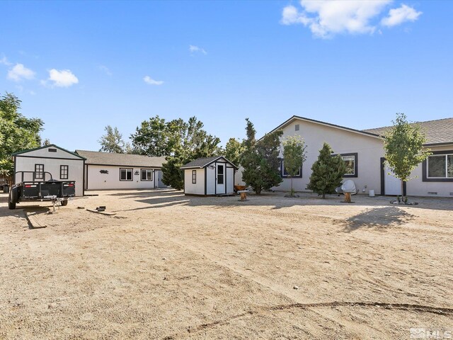 rear view of house with a storage unit