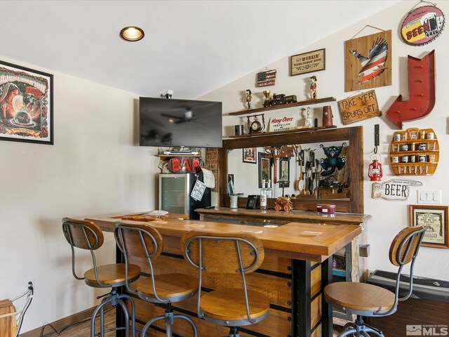 bar featuring vaulted ceiling and wood-type flooring