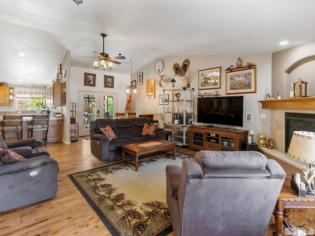 living room with ceiling fan, light wood-type flooring, french doors, and lofted ceiling