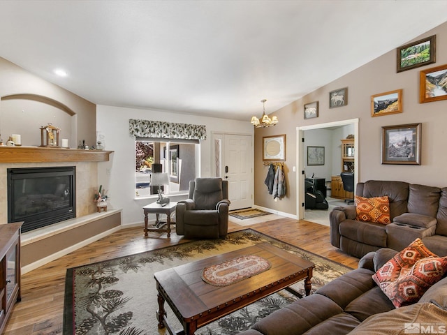 living room with vaulted ceiling, a chandelier, and hardwood / wood-style flooring