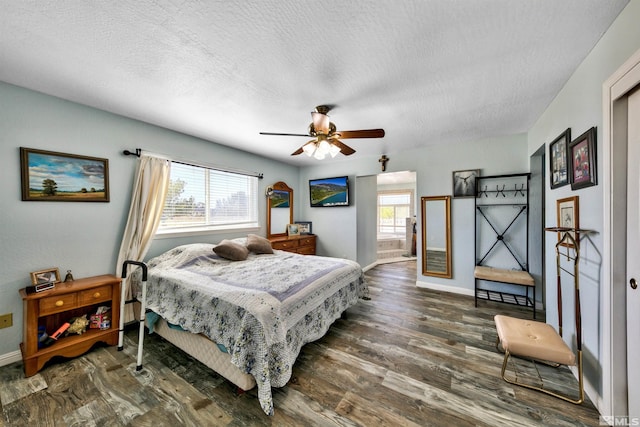 bedroom featuring ceiling fan, dark wood-type flooring, a textured ceiling, and multiple windows