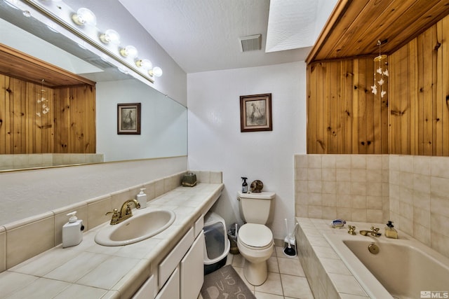 bathroom with tile patterned floors, a tub, vanity, and toilet