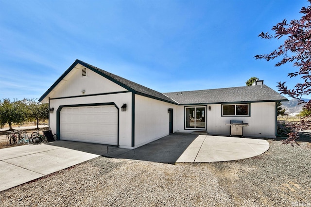 ranch-style house with a garage, concrete driveway, and a shingled roof