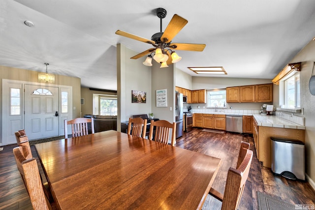 dining area featuring ceiling fan, vaulted ceiling, sink, and dark wood-type flooring