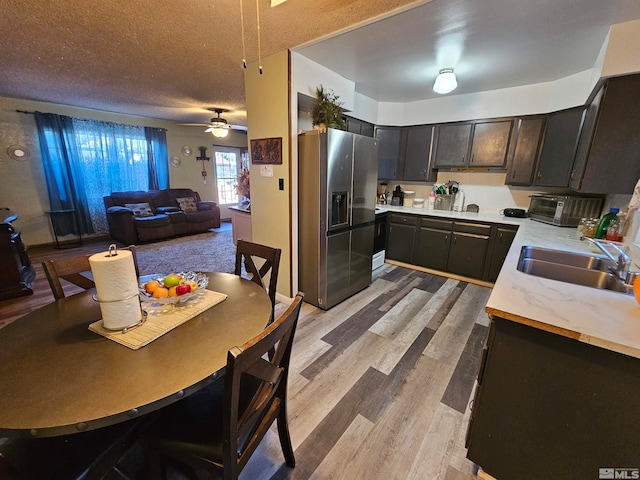 kitchen featuring sink, light wood-type flooring, ceiling fan, a textured ceiling, and stainless steel fridge with ice dispenser