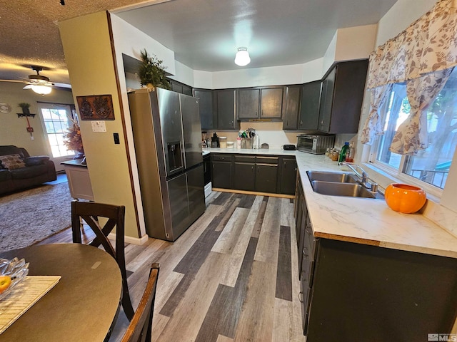 kitchen featuring light hardwood / wood-style flooring, sink, wood counters, stainless steel fridge, and ceiling fan