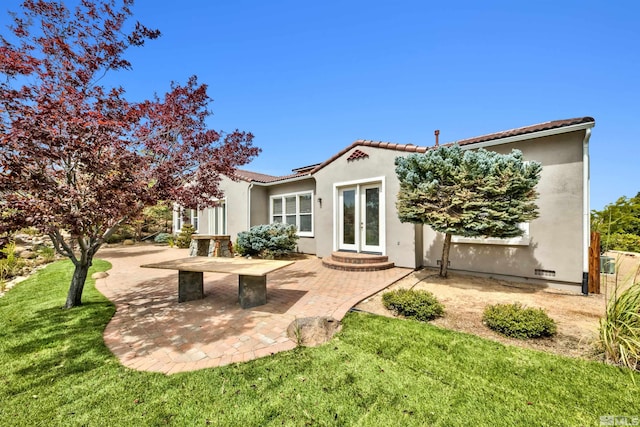 back of property with french doors, a yard, and a patio