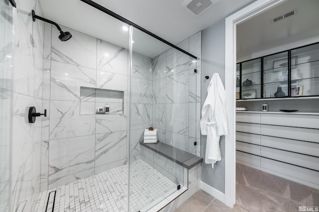 bathroom featuring tile patterned flooring, a shower with door, and vanity