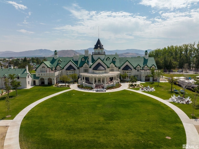 view of property's community with a lawn and a mountain view