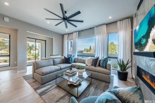 living room featuring ceiling fan and light hardwood / wood-style flooring