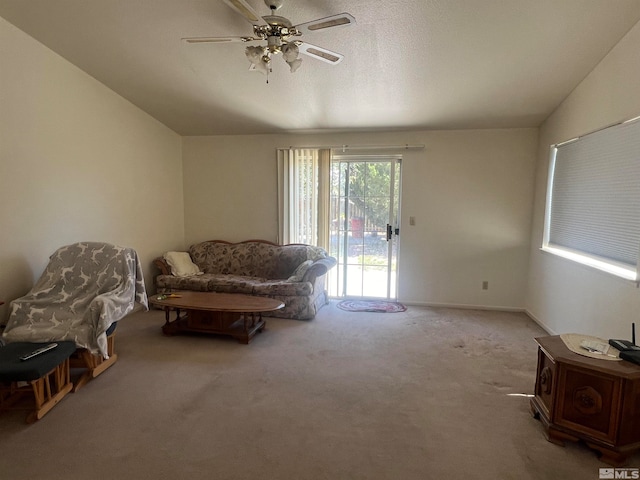 carpeted living room with ceiling fan and vaulted ceiling