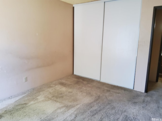 unfurnished bedroom with a closet and carpet flooring