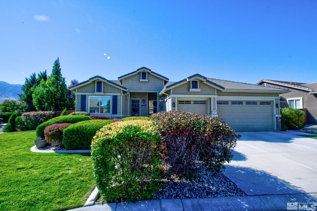 craftsman inspired home with a garage, a front yard, and driveway